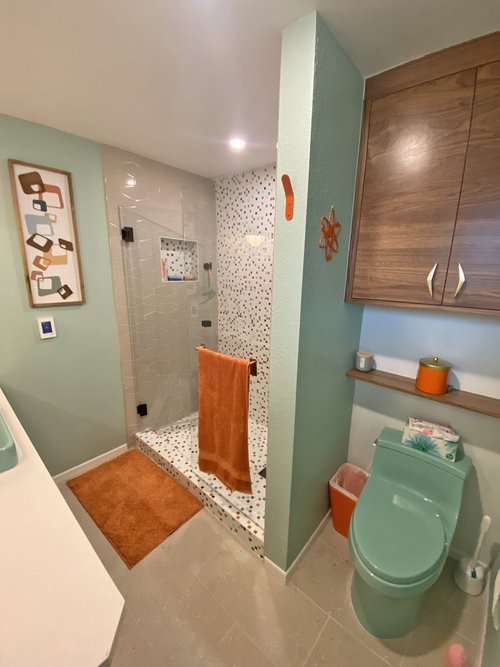 Renovated bathroom with a tiled shower and green fixtures